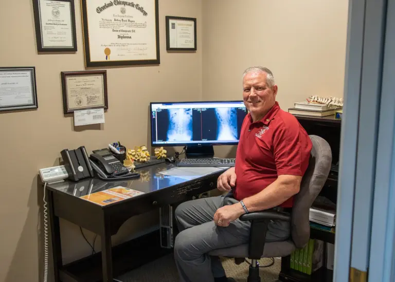 Dr. Jeff Haynes at his desk with spinal X-rays on screen